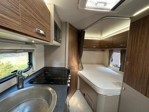 a bathroom with a sink and a kitchen in an rv at Swift Escape 646 Motorhome in Kirton