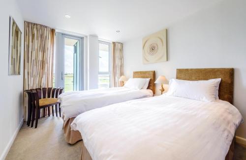 2 camas en una habitación de hotel con sábanas blancas en Surfside 34 Zinc, en Newquay