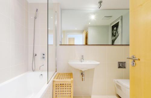 y baño blanco con lavabo y ducha. en Surfside 34 Zinc, en Newquay