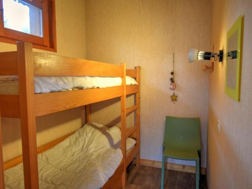 1 Schlafzimmer mit 2 Etagenbetten und einem grünen Stuhl in der Unterkunft Appartement Morzine, 3 pièces, 6 personnes - FR-1-524-72 in Morzine