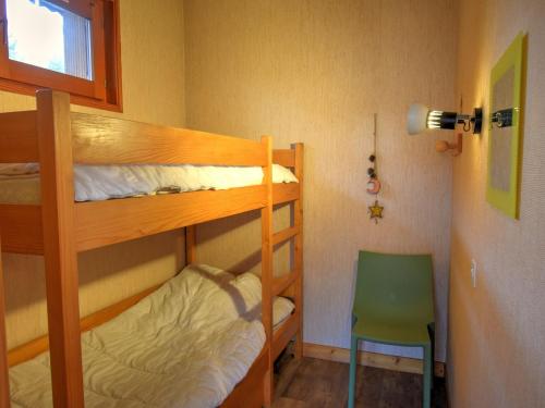 - une chambre avec 2 lits superposés et une chaise verte dans l'établissement Appartement cosy 6 pers. proche pistes avec parking privé - FR-1-524-72, à Morzine
