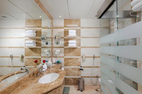 een badkamer met 2 wastafels en een douche bij Diwan Rose Hotel in Al Madinah