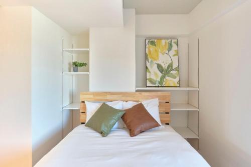1 dormitorio con 1 cama con sábanas y almohadas blancas en Modelo Sangenjaya - Vacation STAY 15699, en Tokio