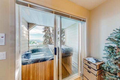 a room with a glass door with a tub outside at SnowCrest Village, Unit 5 in Big White