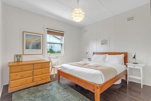 1 dormitorio con 1 cama, vestidor y ventana en Swim Two Birds, en Erowal Bay