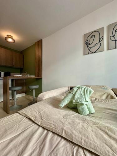 une chambre avec un lit avec une serviette verte dessus dans l'établissement Joli Studio - Nice, à Nice