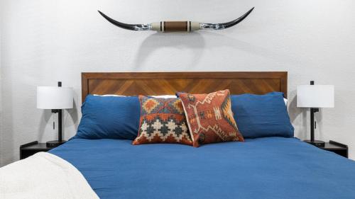 ein Bett mit blauer Bettwäsche und Kissen sowie zwei Lampen in der Unterkunft The Rae | Sequoia Motel RM 5 in Three Rivers