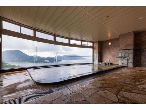 Habitación grande con ventana grande y piscina grande. en Kaikyo View SHIMONOSEKI - Vacation STAY 13686v, en Shimonoseki