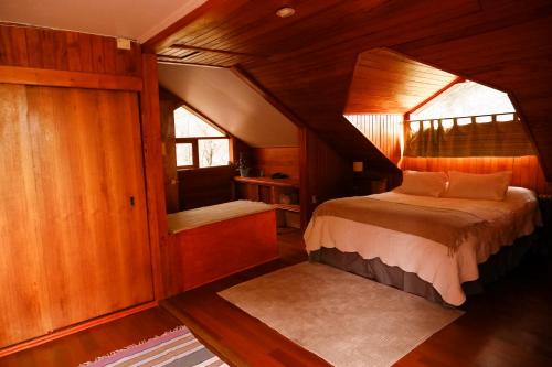 - une chambre avec un lit dans une pièce en bois dans l'établissement Hostel Capanegra, à Castro