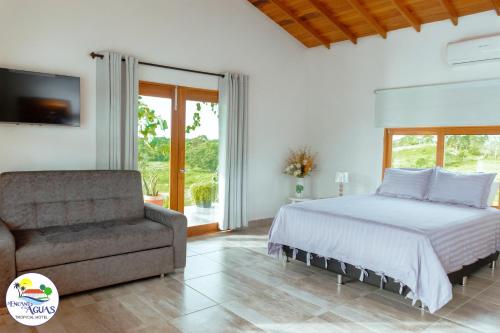 a bedroom with a bed and a couch at El Encanto de las Aguas in Necoclí