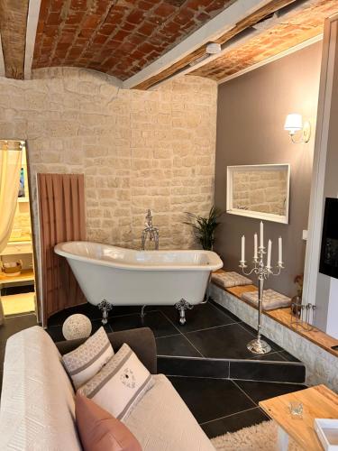 a large bathroom with a tub and a couch at La Grange Aux Hirondelles - Chambre romantique in Woignarue