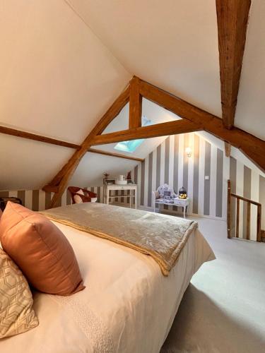 a bedroom with a bed in a attic at La Grange Aux Hirondelles - Chambre romantique in Woignarue