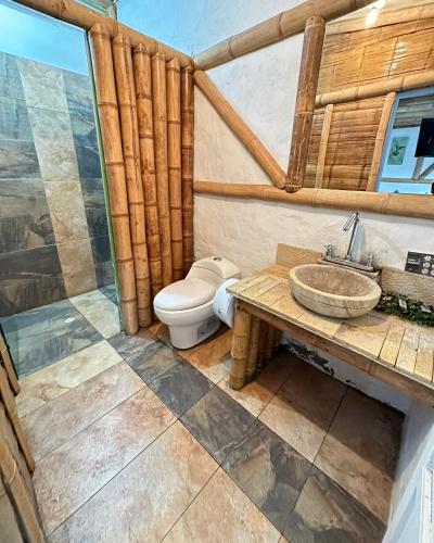 a bathroom with a toilet and a sink at Eco Hotel Terrabella in Santa Elena