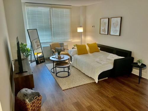 Comfy Getaway by DC,Metro,Airport في أرلينغتون: غرفة نوم بسرير ومخدات صفراء وطاولة