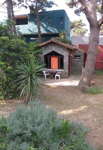una casa con una mesa y un banco en un patio en Cabañas Mar Azul en Balneario Mar Azul