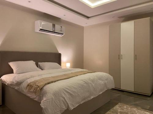 a bedroom with a bed and a white cabinet at شقه (غرفه+صاله)مطله على المركز المالي بدخول ذاتي in Riyadh