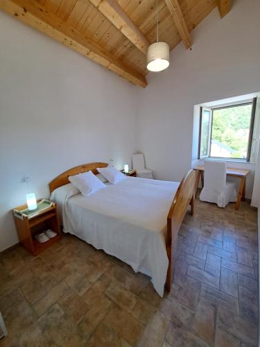 a bedroom with a large white bed and a window at Dolce Dimora in Cascia