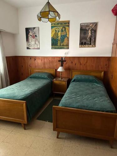 two beds in a bedroom with posters on the wall at Casa con pileta in Tandil