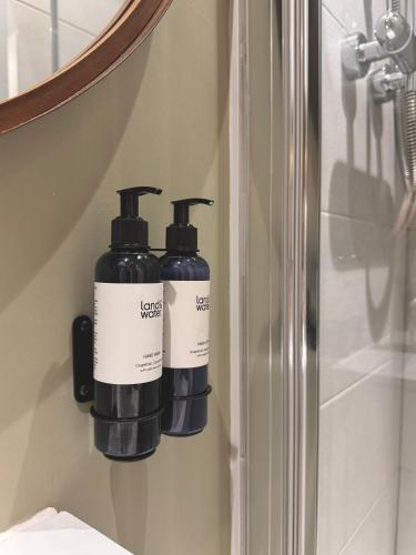 two bottles ofodorizers are hanging on a wall at Y Cwtch Cottage by Birch Stays in Rhosneigr