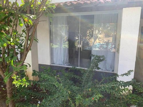 - une fenêtre d'une maison avec des rideaux dans l'établissement Casa de Veraneio com Piscina Perto da Praia, à Lauro de Freitas