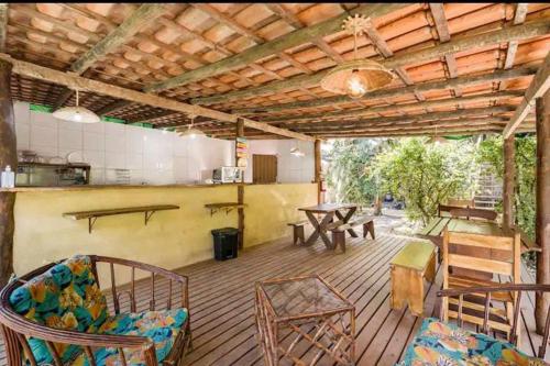 a large wooden deck with a table and chairs at Prumirim Surf Suítes Hotel Ubatuba in Ubatuba