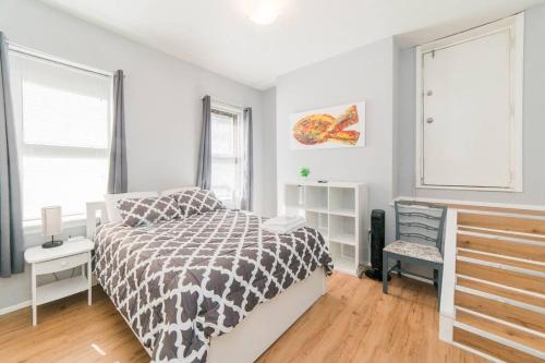 a bedroom with a black and white bed and a window at Parking - Walkable - GroupStays - Washer in Pittsburgh