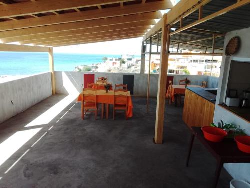 a patio with a table and chairs and the ocean at Pousada Cantinho de Preta in Seladinha