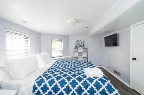 a white bedroom with a blue and white bed at ROKU TVs - Washer & Dryer - QueenBeds - GroupStay in Pittsburgh