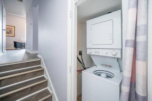 eine Waschmaschine und einen Trockner in einem Zimmer mit einer Treppe in der Unterkunft ROKU TVs - Washer & Dryer - QueenBeds - GroupStay in Pittsburgh