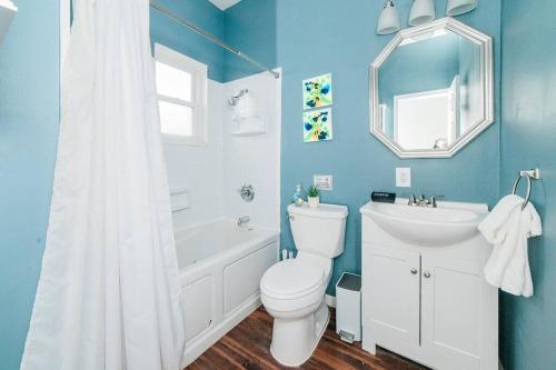 een blauwe badkamer met een toilet, een bad en een wastafel bij Off-Street Parking - Washer & Dryer - GroupStay in Pittsburgh