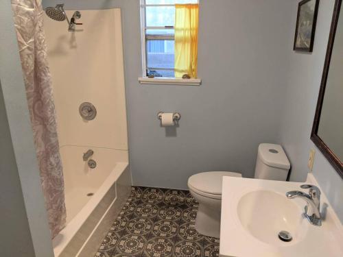 y baño con aseo, lavabo y ducha. en Relax in unpretentious peaceful and authentic house with public transportation cafes and U of Berkeley close by, en Albany