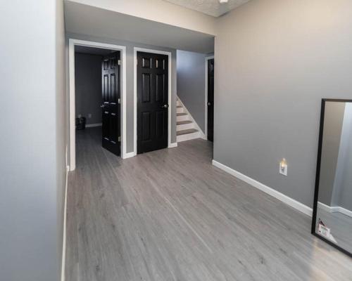 an empty room with two doors and wood floors at IU Soccer HIdeaway in Bloomington
