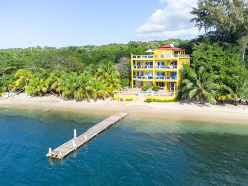 a large yellow building on a beach with a dock at Del Playa #4 Condo in West End