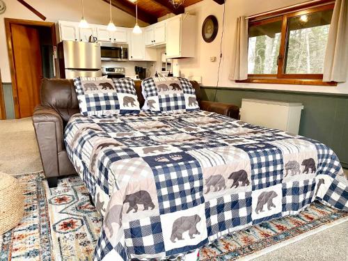 ein Schlafzimmer mit einem Bett mit einer karierten Decke in der Unterkunft White Mountain Escape - Ski Attitash in Bartlett