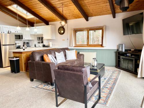 a living room with a couch and a table at White Mountain Escape - Ski Attitash in Bartlett