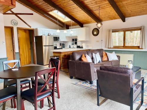 a living room with a couch and a table at White Mountain Escape - Ski Attitash in Bartlett