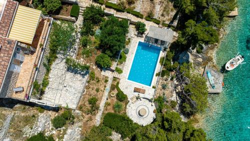 an aerial view of a swimming pool next to the water at Vila Perla in Vela Luka