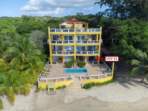 an aerial view of a yellow building on the beach at Del Playa #1 Condo in West End