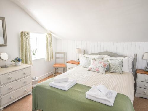 een slaapkamer met een bed met handdoeken erop bij Nutwood in Charmouth