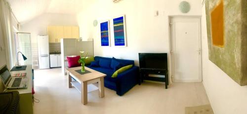 a living room with a blue couch and a table at Apartment Art Adriatic in Punat
