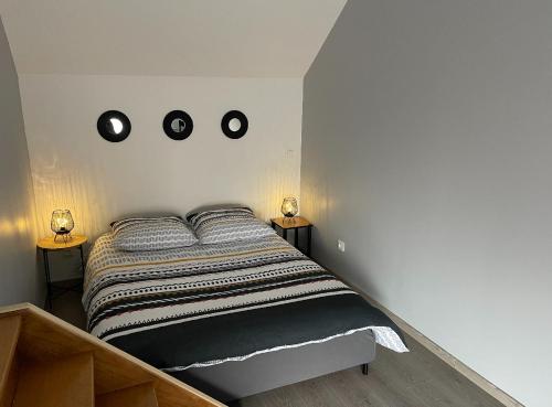 una camera da letto con un letto con due luci sul muro di Appartement Amiens-Camon a Camon