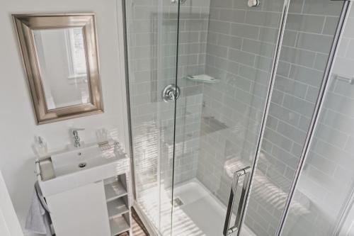 baño con ducha y puerta de cristal en The Trafalgar, en Oakville