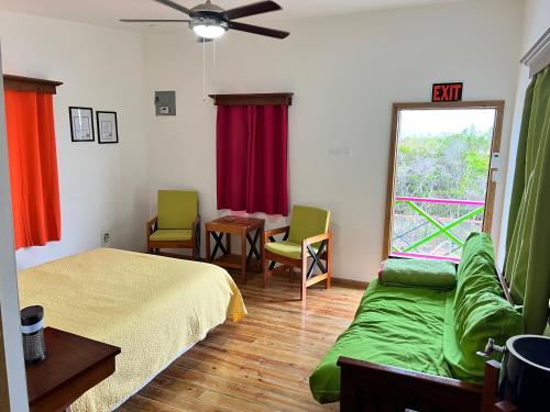 sypialnia z łóżkiem, stołem i oknem w obiekcie West End Cabanas w mieście San Pedro