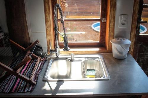 a sink in a kitchen with a window at Chalé Sol da Montanha em Termas do Gravatal - SC in Gravatal