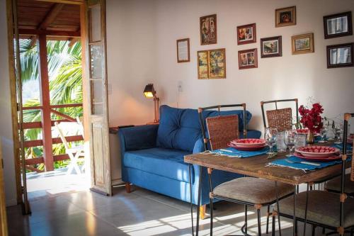 uma sala de estar com um sofá azul e uma mesa em Chalé Sol da Montanha em Termas do Gravatal - SC em Gravatal