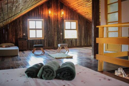 a room in a cabin with a bed and two windows at Chalé Sol da Montanha em Termas do Gravatal - SC in Gravatal