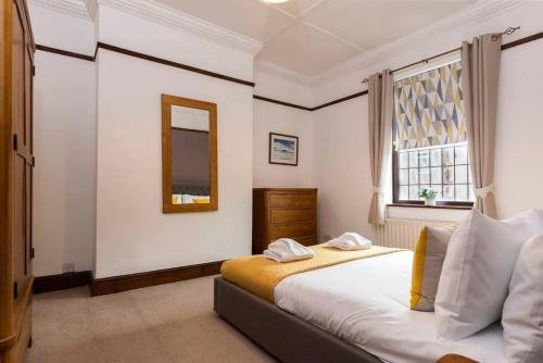 1 dormitorio con cama con espejo y ventana en Linden Cottage en Coxhoe