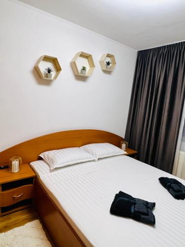 a bedroom with a bed with a black bag on it at Best Rent Apartments in Giurgiu