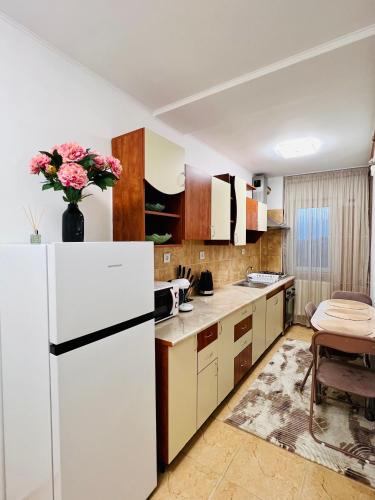 a kitchen with a white refrigerator and a table at Best Rent Apartments in Giurgiu