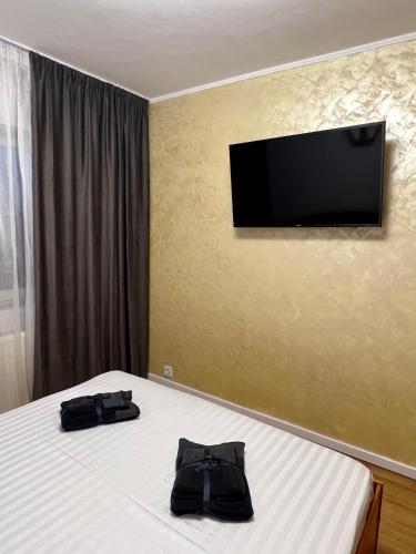 a bedroom with a bed with a television on the wall at Best Rent Apartments in Giurgiu